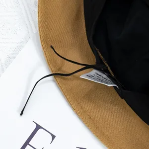 Détail intérieur d'un chapeau bob en velours côtelé camel avec doublure noire et cordon