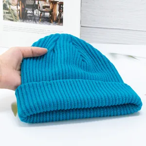 Close-up of a bright blue knitted beanie showing soft ribbed texture and thick material