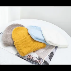 Plano detalle de gorros de punto acanalado en cuatro colores con textura de pelo de conejo