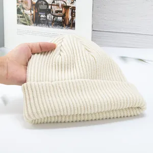 Detail of cream rib-knit beanie showing soft texture and wide fold-over cuff design