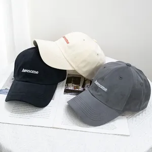 Trois casquettes de baseball en coton noir, beige et gris avec broderie Awesome sur magazine