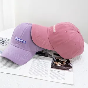 Détail de la broderie Awesome sur les casquettes de baseball en coton mauve et rose