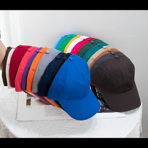 Multiple colors of washed cotton baseball caps stacked neatly on a bright surface