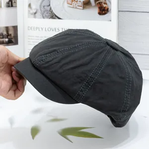 Detail of dark grey canvas newsboy cap showing eight-piece panels and neat stitching