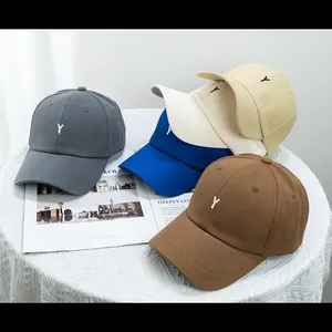 Vue détaillée de casquettes en coton avec broderie Y en gris, bleu et tons beiges
