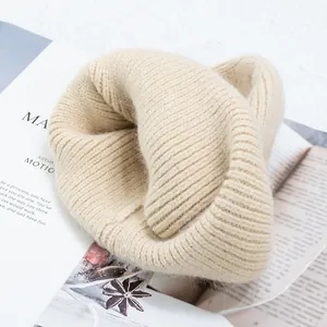 Detalle de gorro de punto acanalado beige de piel de conejo sobre fondo minimalista