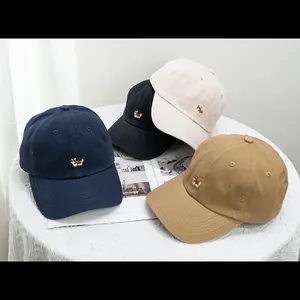 Cute Corgi embroidery baseball caps in multiple colors on a stylish lace table
