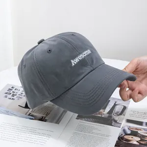 Détails de la broderie 'Awesome' sur une casquette de baseball en coton gris foncé