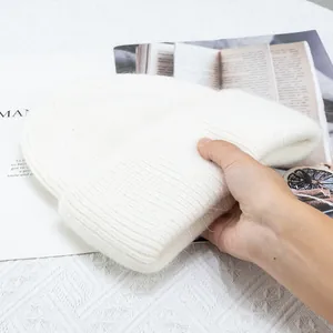 Primer plano del gorro de punto blanco esponjoso con dobladillo grueso y tacto suave