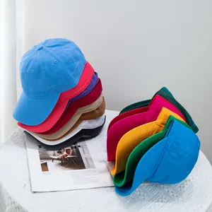 Close-up of vibrant cotton canvas baseball caps stacked on a table with magazine