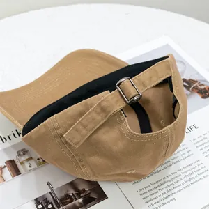 Detail of khaki cotton baseball cap showing adjustable metal buckle and back strap