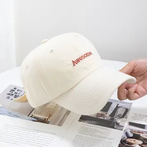 Détail de la casquette crème avec broderie 3D 'Awesome' et texture en toile de coton