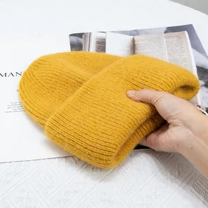 Detalle del gorro de punto acanalado amarillo jengibre con textura de pelo suave