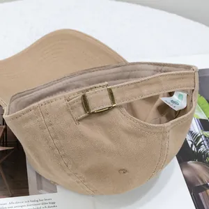 Detail of khaki cotton baseball cap showing vintage metal buckle and AQL quality tag