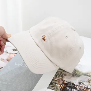 Close-up of cute Corgi dog embroidery on cream white cotton baseball cap details