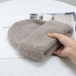 Primer plano de gorro de punto de piel de conejo marrón claro con textura de lana suave