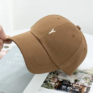 Détail de la broderie blanche de la lettre Y sur une casquette en coton sergé kaki