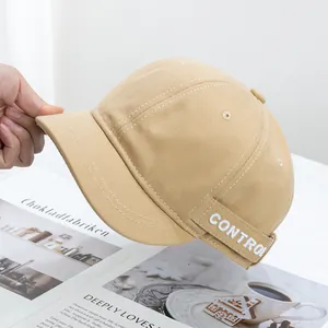 Dettaglio del cappello docker kaki in tela con ricamo bianco 'CONTROL' sul lato