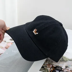 Close-up of cute Corgi dog embroidery on black cotton twill baseball cap fabric