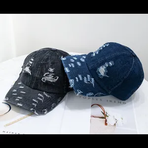 Close-up of distressed denim baseball caps with ripped details and vintage wash texture