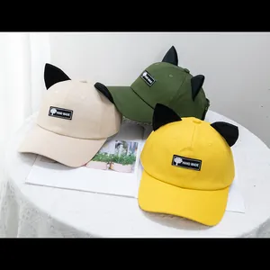 Primer plano de gorras de béisbol con orejas de gato en beige, verde oliva y amarillo