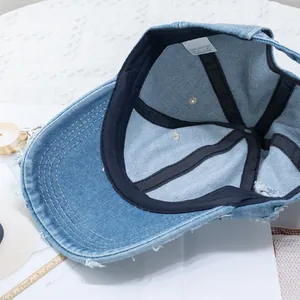 Distressed blue denim baseball cap made of 100% cotton with vintage ripped details
