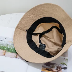 Detailed macro view of khaki cotton bucket hat interior with sweatband and wash label
