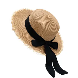 Chapeau de paille à haut plat pour femme avec ruban noir et bords effilochés sur blanc