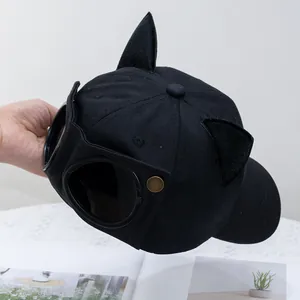 Detalle de gorra negra con orejas de gato y gafas de piloto en la parte posterior