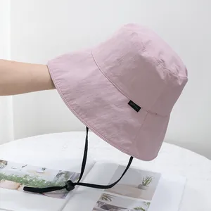 Detail of light pink sun hat with quick-dry nylon texture and adjustable black drawstring