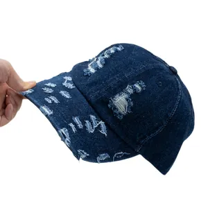 Distressed vintage dark blue denim baseball cap with torn details and washed cotton finish