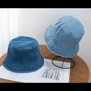 Top view of two distressed denim bucket hats in dark and light blue with stitched brims