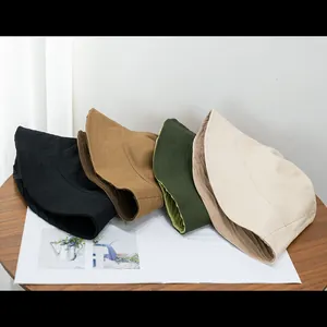 Minimalistische Fischerhüte für Paare in vier Unifarben auf einem weißen Magazin