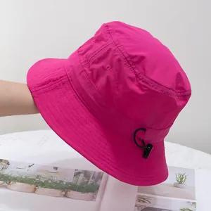 Detail of hot pink bucket hat featuring adjustable black drawstring and reinforced stitching