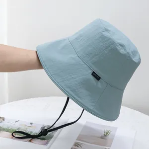 Close-up of lightweight blue sun hat with adjustable windproof cord and side label
