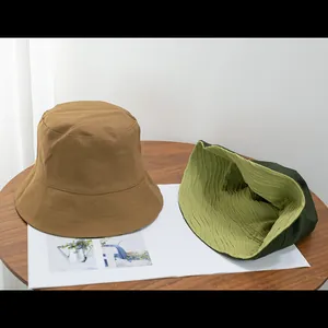 Detailansicht von Baumwoll-Anglerhüten mit Wellenstruktur und Nähten auf einem Holztisch