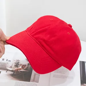 Close-up of red cotton baseball cap showing reinforced curved brim and stitching detail