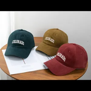 Detail of embroidered COLORADO logo on cotton baseball caps in multiple colors