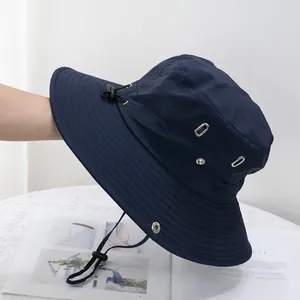 Detail of dark blue sun hat featuring metal eyelets and adjustable chin strap cord