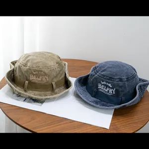Flat lay of vintage khaki and blue denim bucket hats with embroidery on a wooden table
