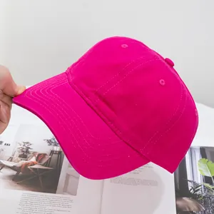 Detail of rose red cotton baseball cap with six-panel structure and curved brim