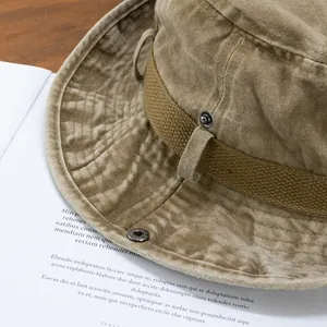 Detailed close-up of khaki washed canvas bucket hat with metal snaps and texture