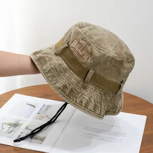 Close-up of vintage khaki sun hat with embroidery detail and adjustable chin strap