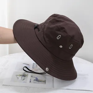 Close-up of dark brown quick-dry sun hat showing breathable metal vents and adjustable cord