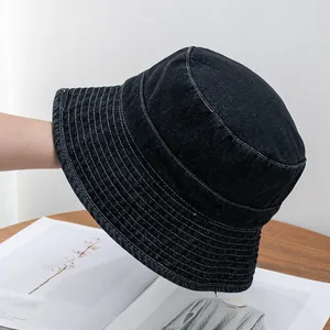Detailed view of the dark denim bucket hat showing neat parallel white stitching on brim