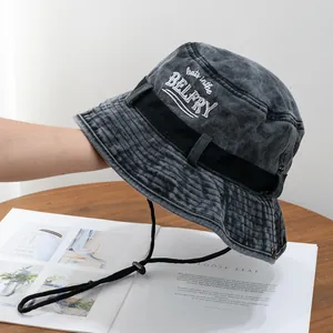Close-up of charcoal grey washed denim hiking hat with white embroidery and chin strap