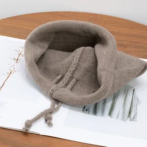 Brown knitted drawstring hooded cowl scarf with soft texture on a wooden table