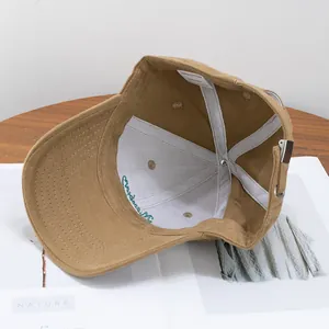 Khaki brushed cotton baseball cap with Kingston embroidery on wooden background