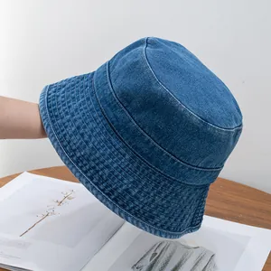 Detail of washed denim bucket hat showing white multi-row stitching and quality fabric
