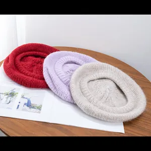 Detail of red, purple, and off-white mohair berets showcasing soft knitted wool textures